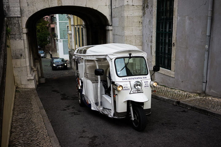 Tuk Tuk driving up a street in Lisbon