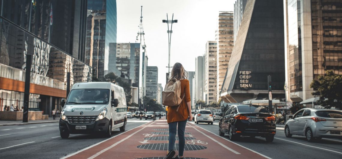 girl with backpack in the middle of a city street