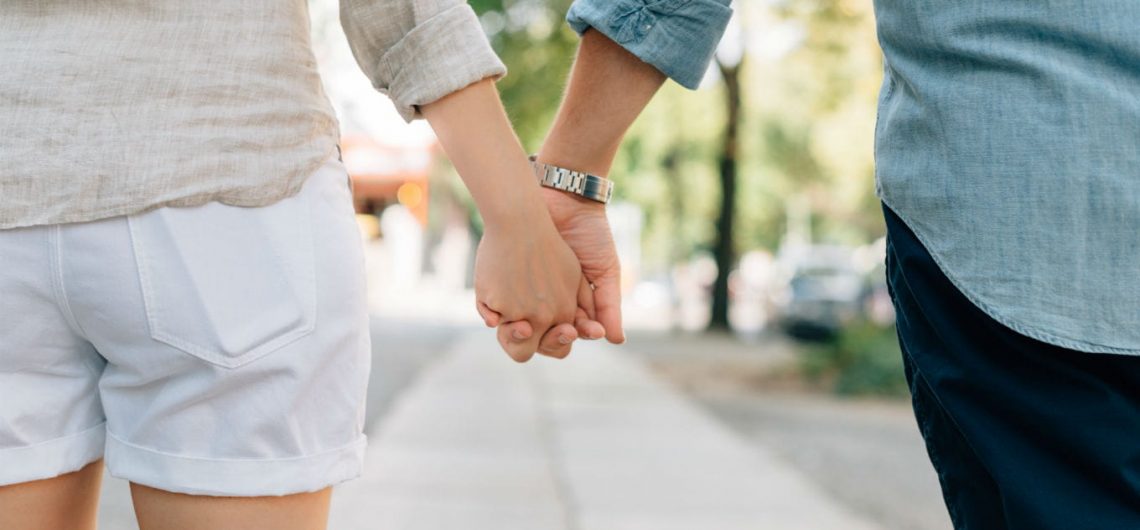 A couple holding hands while walking