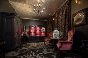 Habitación sin gente y decorada con muebles oscuros y dos sillas de terciopelo.
