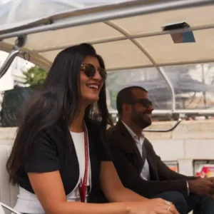 Two people smiling while travelling in a tuk tuk