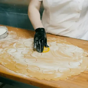 Person holding a mold against a dough